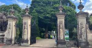 Historic entrance gate with trees in background.
