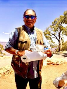 Smiling man with sunglasses holding paper towels outside