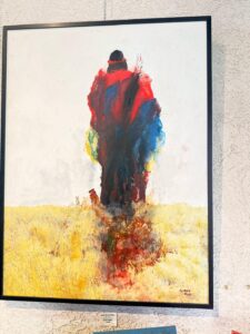 Abstract painting of colorful figure in a field.