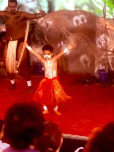 Child and adults in traditional dance performance.