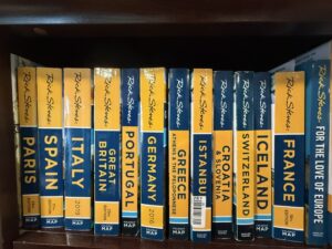 Travel guidebooks for various European countries on shelf.