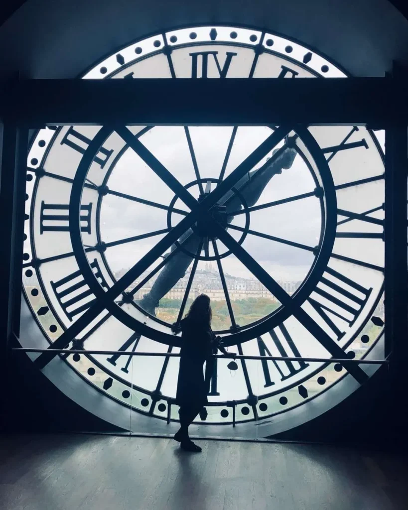 Silhouette of person inside giant clock face.