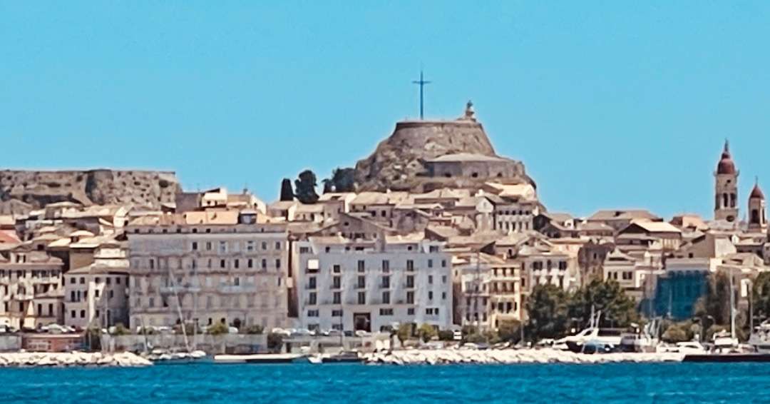 Greece Best Places to Visit Buildings on waterfront with cross on church in back
