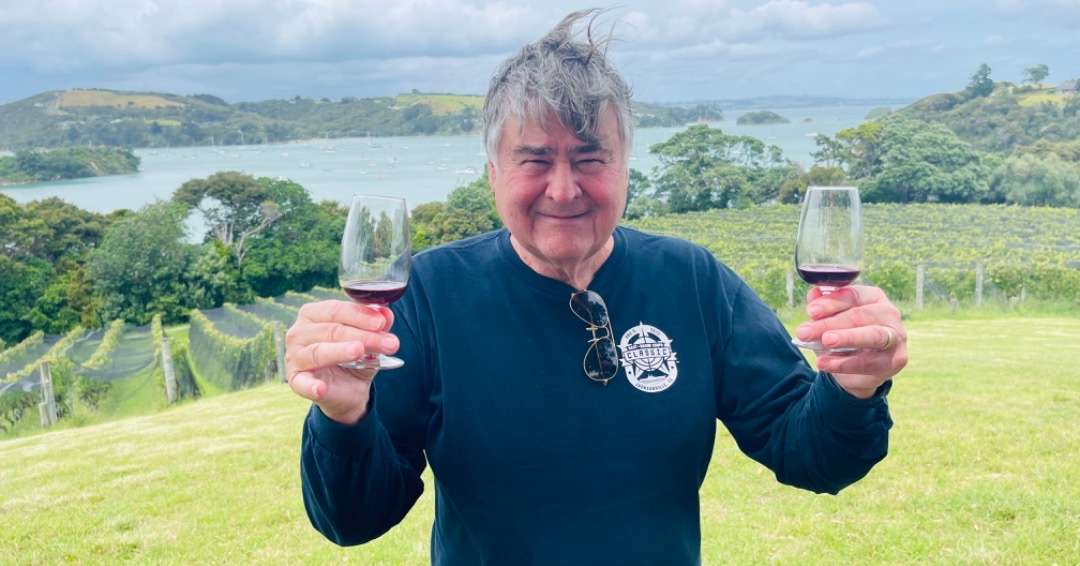 Cos holding up two glasses of wine