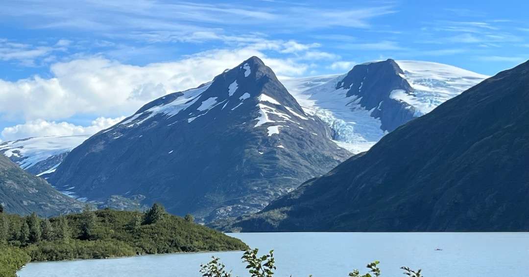 When is the best time to Visit Alaska? Glacier on mountain above lake. Best destinations for couples