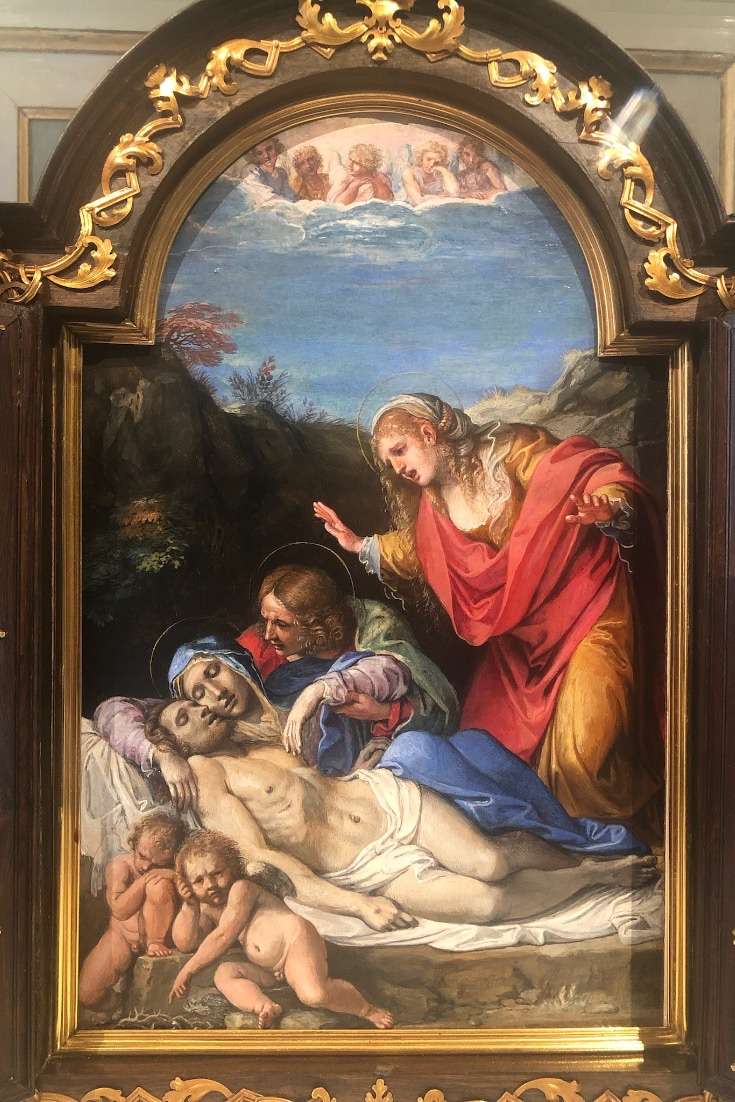 Painting with elaborate frame of three women and dying Jesus as well as two naked baby angels in Barberini Plaza
