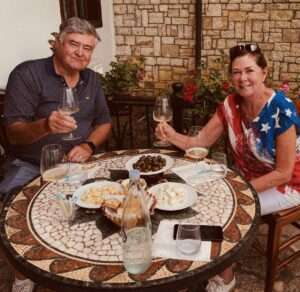 Couple enjoying wine and snacks outdoors at mosaic table