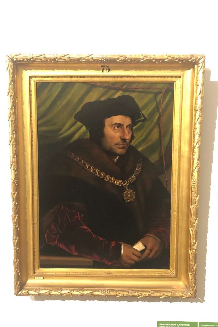 Painting of man with chain around his neck against a green background in the Piazza Barberini in the Rione Tevi section of Rome