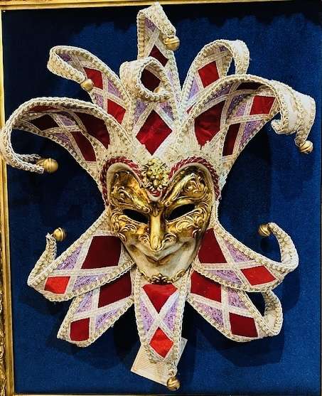 Venetian smiling mask of elf with Gold, Red, White, Purple decorations on a dark blue background from Skhoder, Albania