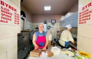 Woman smiling in bakery with text menu on wall ; favorite Restaurants