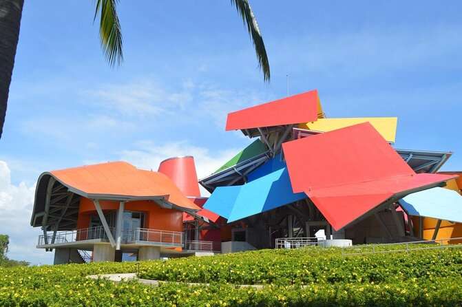 Biomuseo in Panama City is a mixture of several roofs, each with a different color including orange, red, yellow and blue that sits next to the cultivated garden