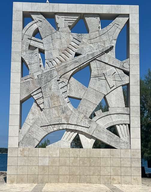Marble monument with soldier aiming a gun pointing to a woman and man in Croatia