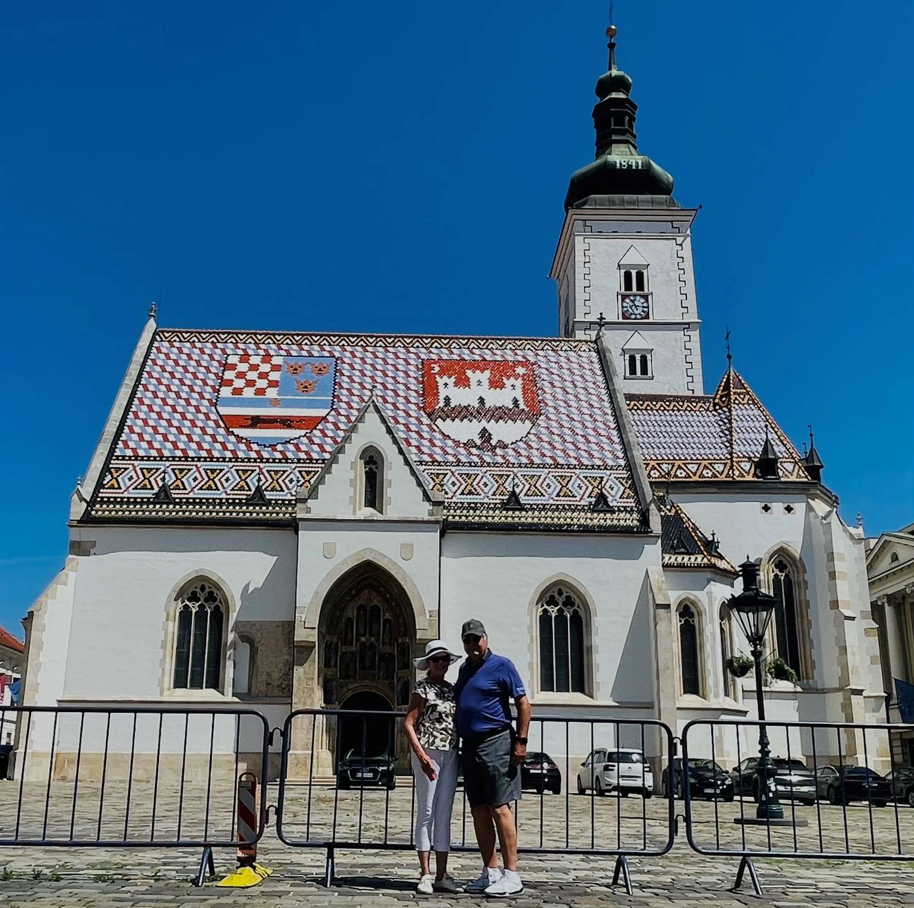 Robin and Paul in front of this former church building with colorful roof tiles in Zagreb, Croatia