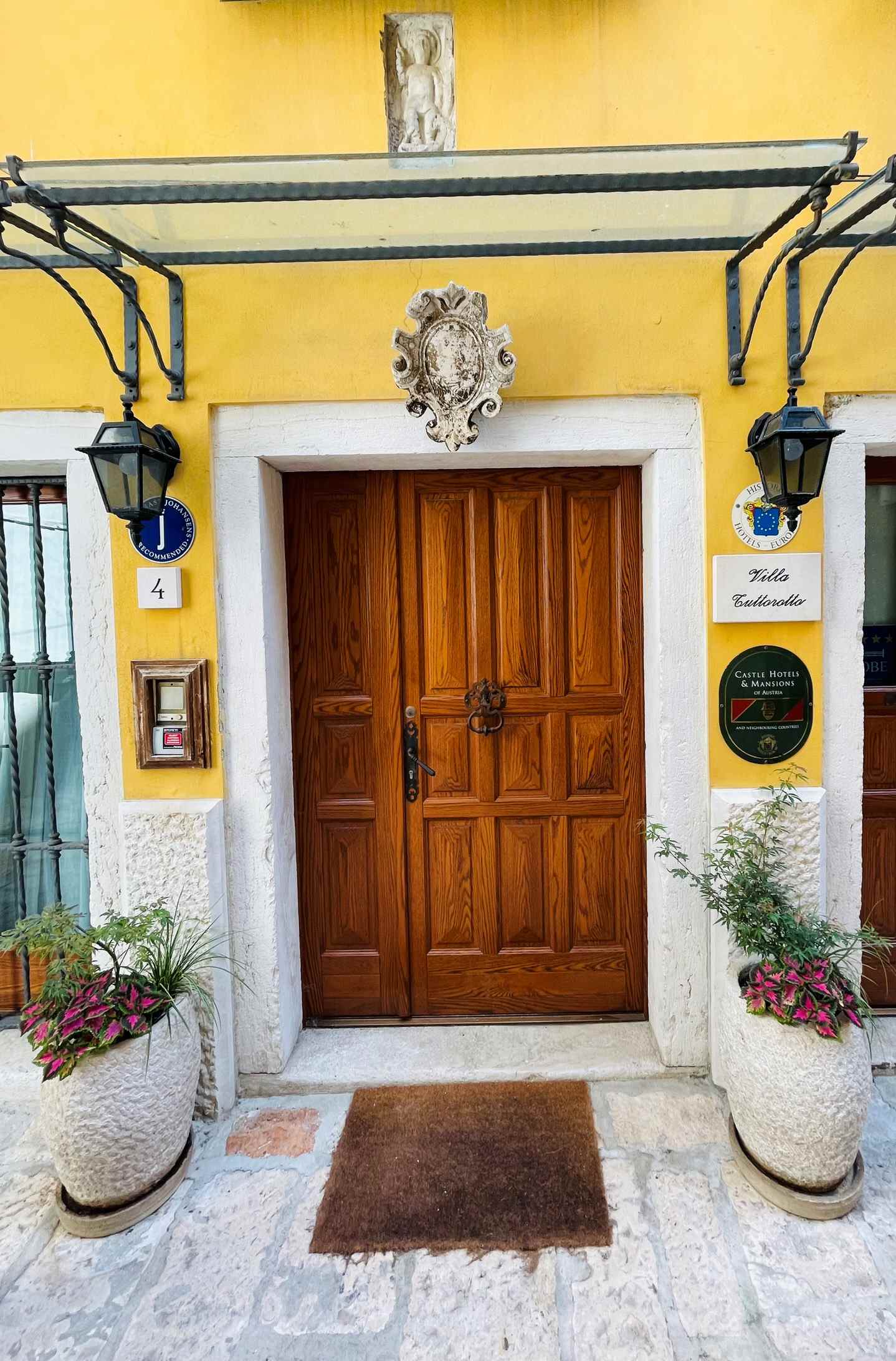 Yellow guest house with wooden door and sign in Rovinj, Croatia