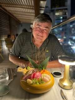 Paul is happy with his appertizer which is highlighted by the table lamp at this restaurant in Panama City