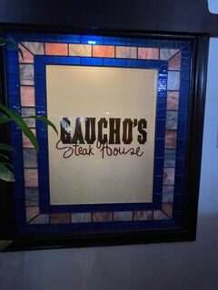 Colorful backlit sign for Gaucho's Steak House with blue highlights