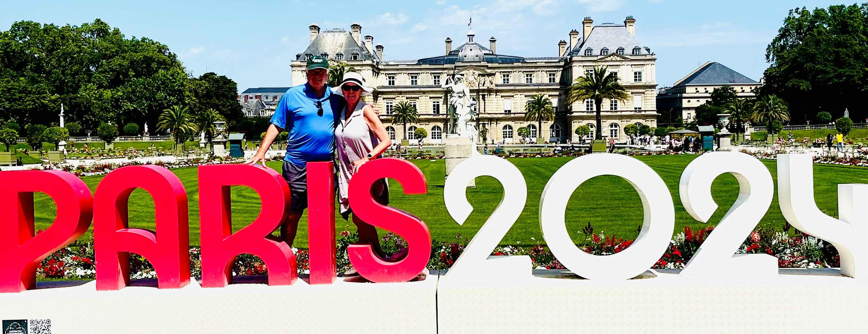 Cos and Robin in front of Paris 2024 sign in Luxembourg garden