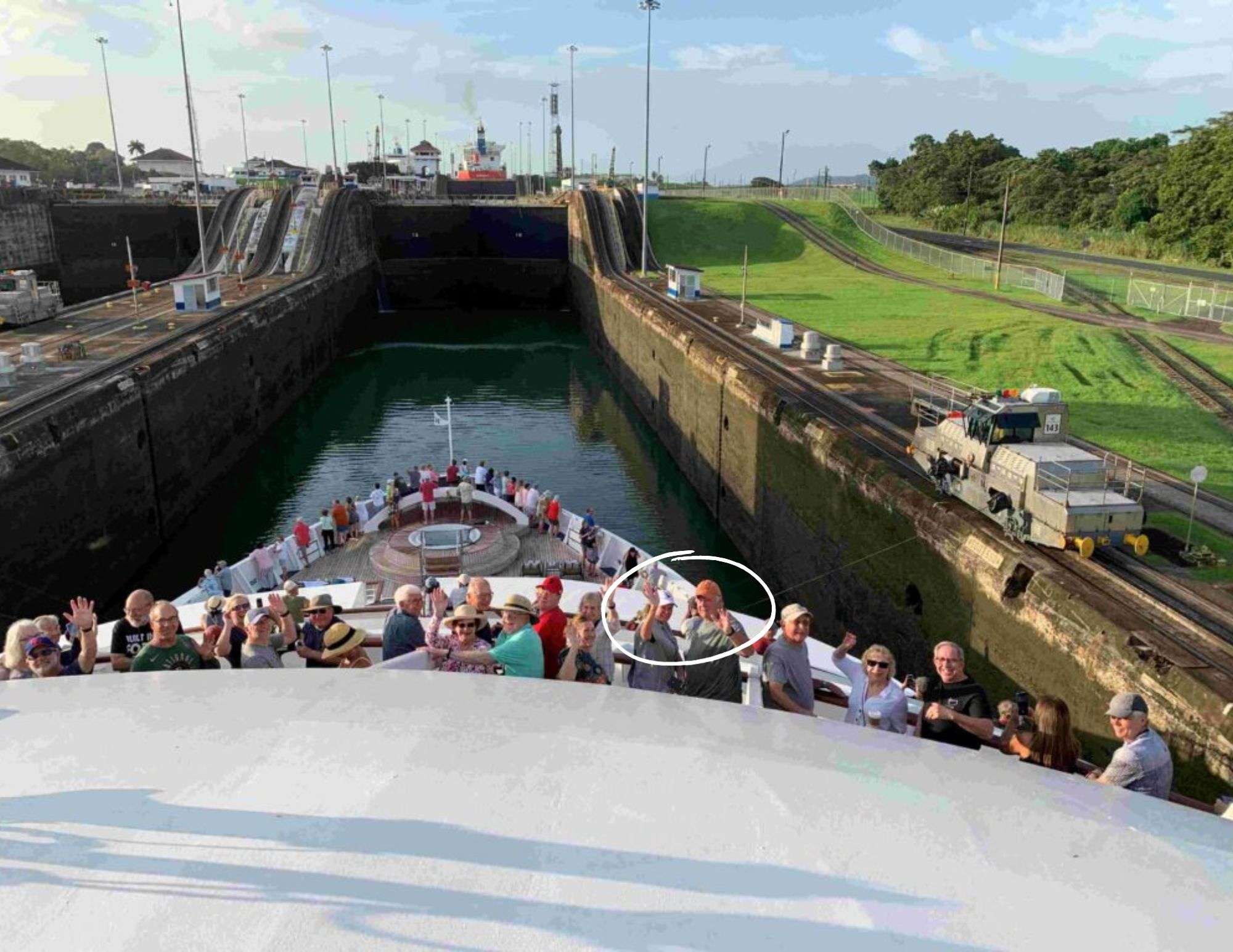 Cruise ship with waving passengers navigating the Panama Canal under the Centennial Bridge