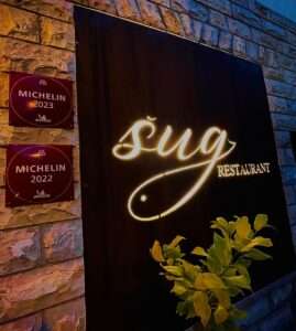 Michelin-starred Sug Restaurant illuminated sign at night