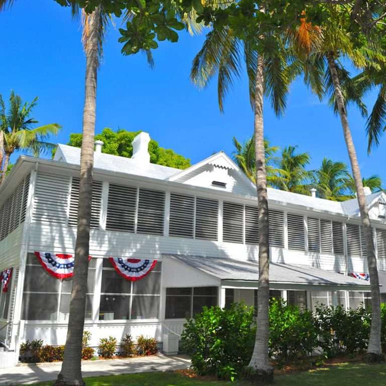 The Little White House, draped with red, white and blue banners sits in the shade on Key West