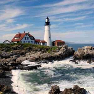 New England Road Trips: White lighthouse with red roof on rocky coastline