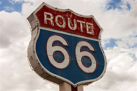 Weathered Route 66 sign against cloudy sky