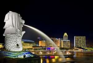Singapore's Merlion statue at night with city skyline.