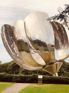 Metallic flower sculpture in a park setting
