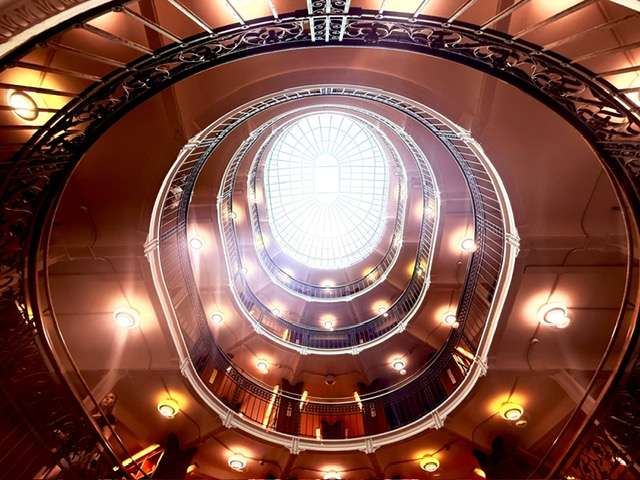 Looking up at spiral staircase with skylight
