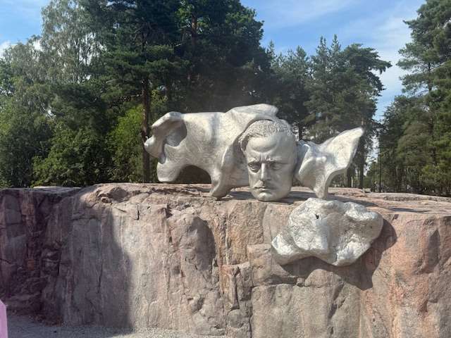 Abstract stone sculpture on a rock in forest.