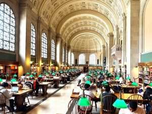 People studying in a large library reading room.