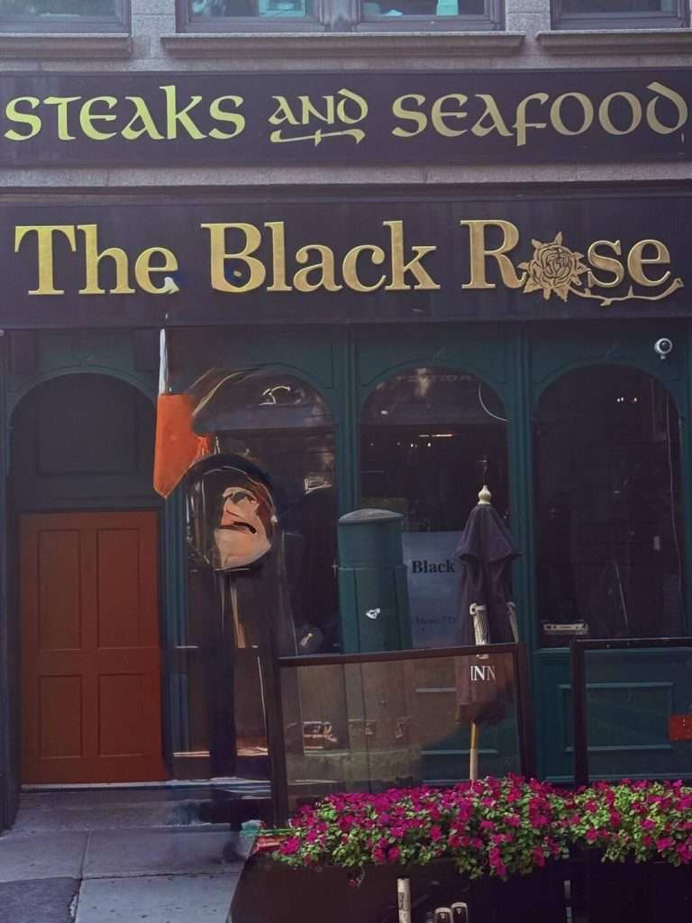 The Black Rose pub entrance with flower display.