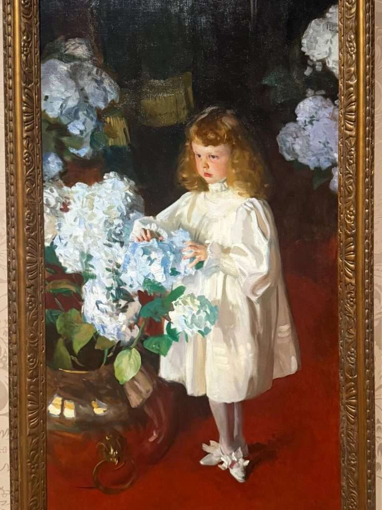 Portrait of child with white flowers, red background.