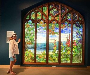 Person admiring colorful stained glass window