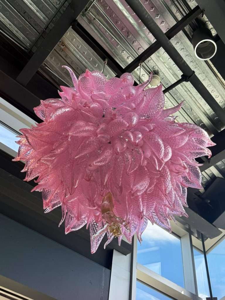 Pink glass sculpture hanging from ceiling