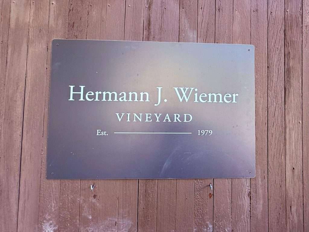 Hermann J. Wiemer Vineyard sign on wooden wall.