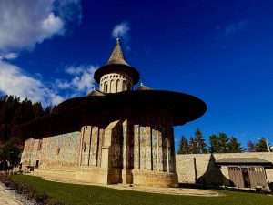 Historic painted monastery with a scenic blue sky.