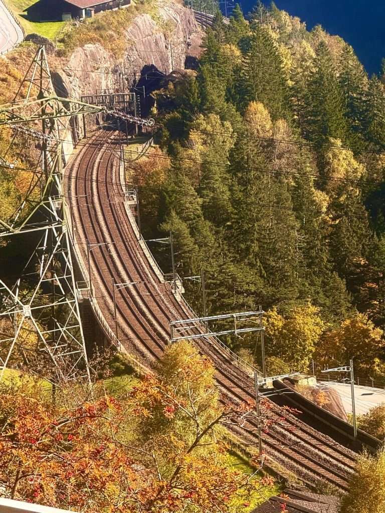 Curving railway through forested mountain landscape.