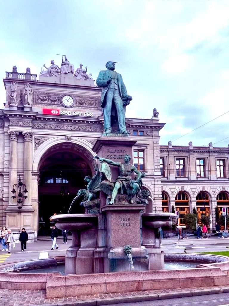 Zurich train station statue and fountain prominently displayed.
