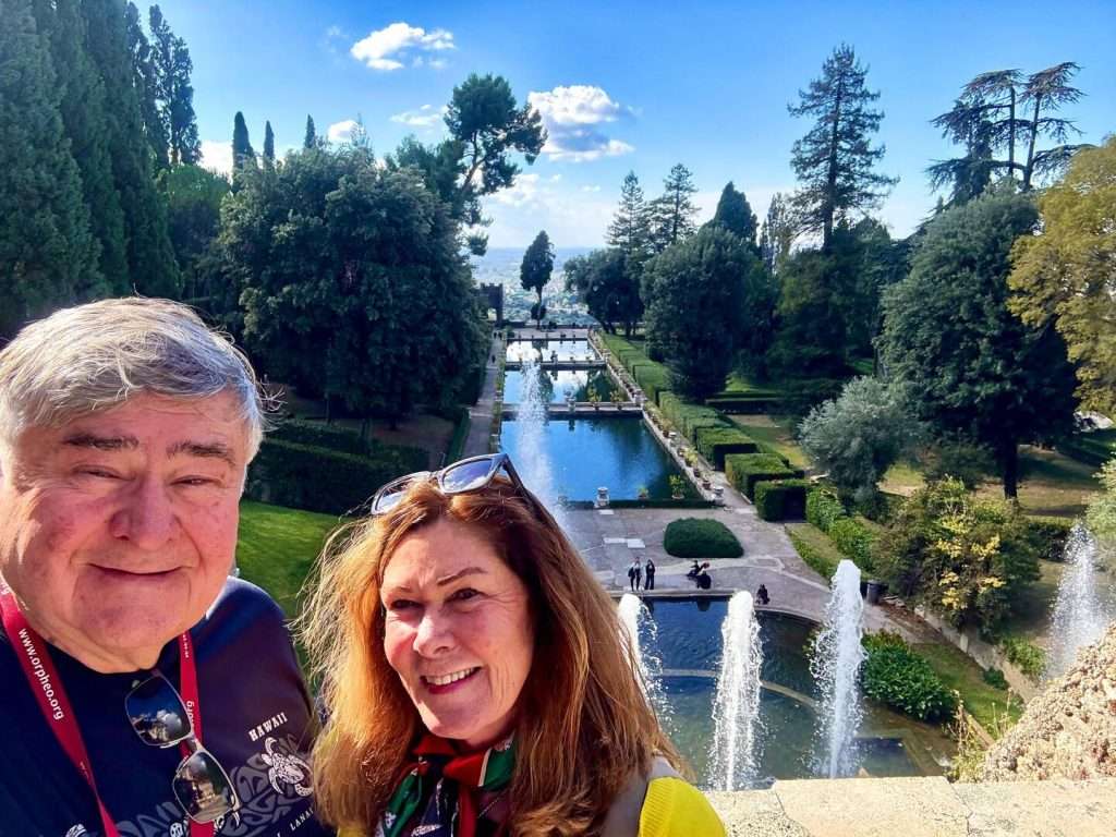 Private Excursions from Rome: Couple smiling in lush garden with fountains.