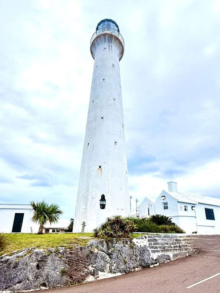 Tall white lighthouse with blue sky background.