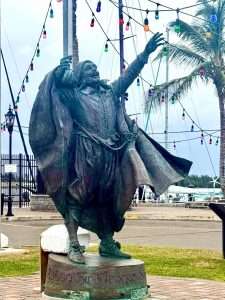 Statue of historical figure with colorful lights.