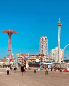 Amusement park rides and boardwalk on sunny day.
