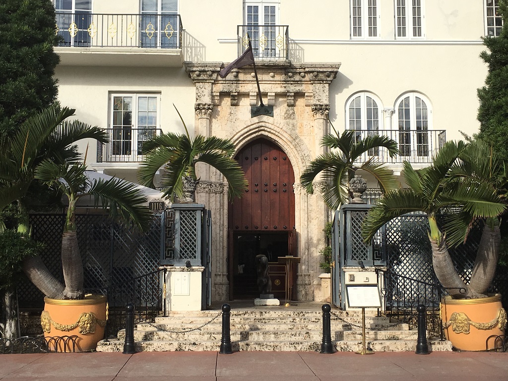 Historic building entrance with palm trees and staircase