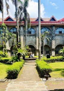 Historic courtyard with people and palm trees.