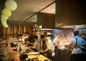 Chefs working in a busy open kitchen restaurant.