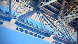 People walking on bridge structure under clear sky.