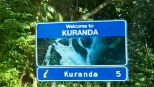 Welcome to Kuranda sign with waterfall image.