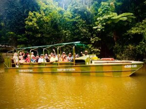 Tourists on a jungle boat tour in rainforest.