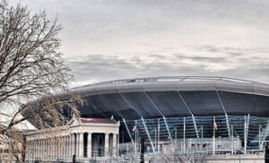 Stadium exterior with train and winter trees.